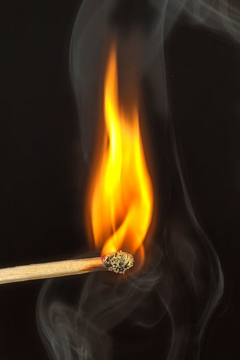 A detailed view of a matchstick burning with bright flame against a dark background, emitting smoke. HD phone wallpaper