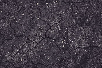 Close-up of cracked earth with dark tones, showcasing natural textures and patterns. HD wallpaper