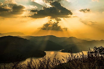 Breathtaking view of sunset rays over mountains and lake in Kerala, India. HD wallpaper