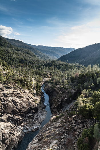 Explore the stunning landscape of Groveland, CA with rocky valleys and a flowing river under a clear sky. HD phone wallpaper