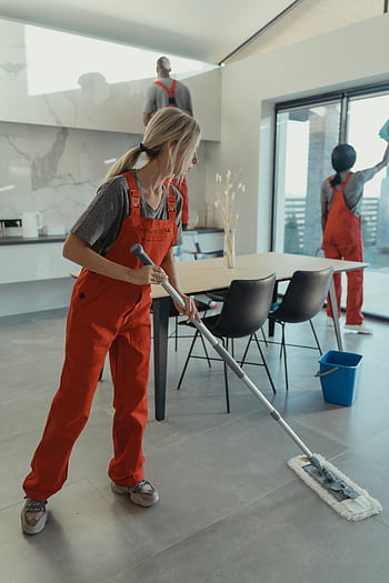 Cleaning team in red overalls mopping and sanitizing a modern home interior. HD phone wallpaper