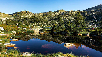 Deep blue lake, trees, sky, mountains, stones, reflections HD wallpaper