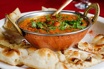 Delicious Indian curry garnished with cilantro served with naan in a copper dish. HD wallpaper