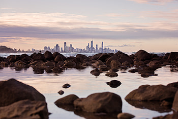 Seashore Rocks Near City View Of Buildings , seashore, nature, city, buildings, rocks, graphy HD wallpaper