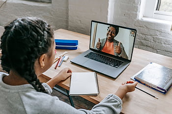 A young student connecting with a teacher via video call for an online lesson. HD wallpaper