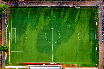 Drone shot of a soccer field in Jakarta, Indonesia with players practicing. HD wallpaper