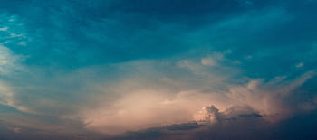 Serene sky with soft clouds illuminated during sunset, perfect for peaceful backgrounds. HD wallpaper