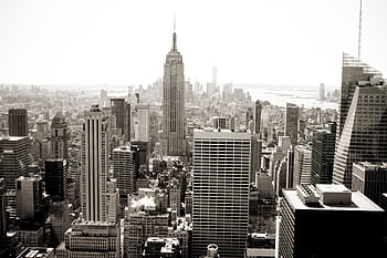Aerial view of Manhattan's iconic skyline featuring the Empire State Building in monochrome. HD wallpaper