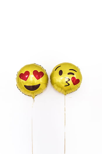 Two yellow emoji balloons with playful expressions on a white background. HD phone wallpaper