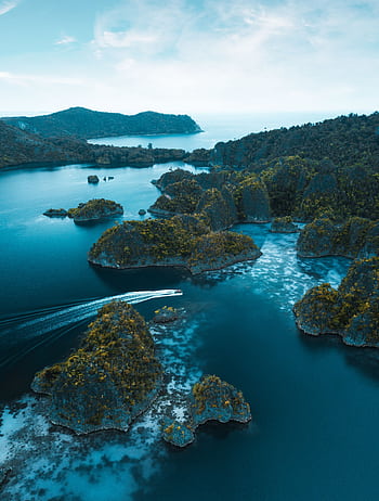 Stunning aerial view of Raja Ampat's blue waters and unique rock formations in West Papua, Indonesia. HD phone wallpaper