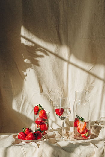 Beautiful still life of strawberries in glasses and carafe with natural light and shadows. HD phone wallpaper
