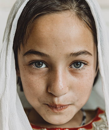 Charming portrait of a young girl with a headscarf, showcasing natural beauty and innocence. HD phone wallpaper
