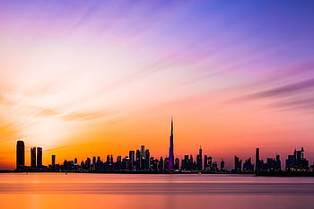 Beautiful view of the Dubai skyline featuring Burj Khalifa during a colorful sunset. HD wallpaper