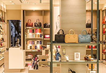 Chic boutique with a variety of handbags and shoes elegantly displayed on shelves. HD wallpaper