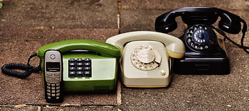 A variety of antique, vintage, and modern teles displayed on pavement. HD wallpaper