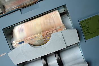 50 Euro banknotes being processed in a high-speed counting machine, showcasing technology and finance in action. HD wallpaper