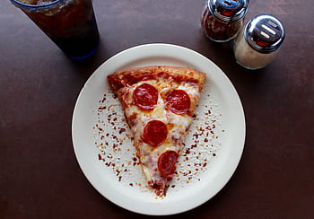 A mouthwatering slice of pepperoni pizza with cheese and spices, ideal for any meal. HD wallpaper