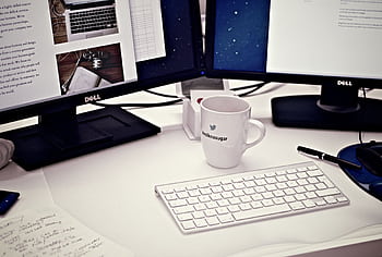A contemporary workspace featuring dual Dell monitors, a keyboard, and a Twitter mug. HD wallpaper