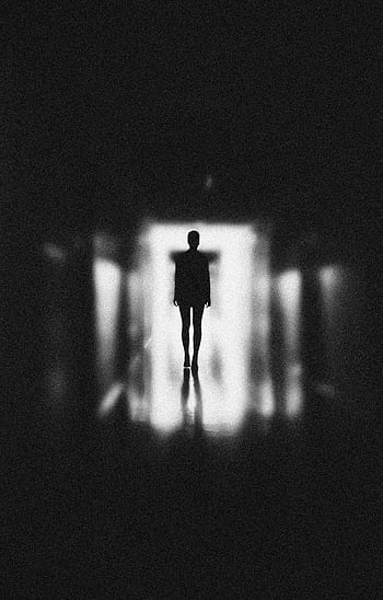 Moody silhouette of a person in a blurred, black and white corridor. Capturing themes of solitude and mystery. HD phone wallpaper