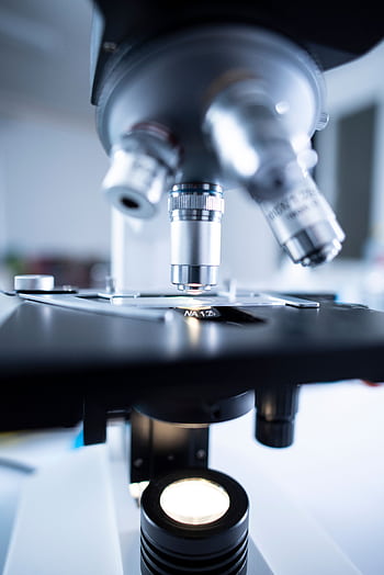 Detailed view of a laboratory microscope focusing on lens and optical components. HD phone wallpaper