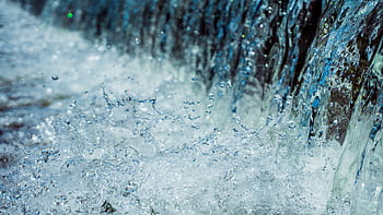 Close-up of water splashing with droplets in motion, showcasing nature's dynamic beauty. HD wallpaper