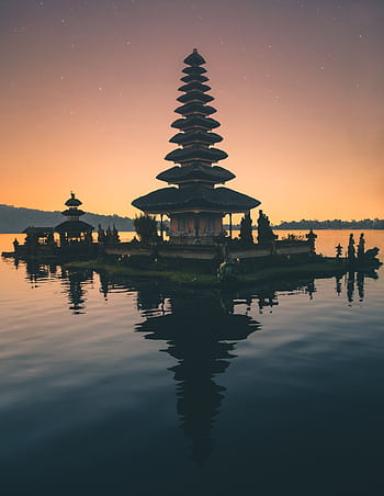 Tranquil reflection of Balinese pagoda on a lake at twilight, capturing spirituality and peace. HD phone wallpaper