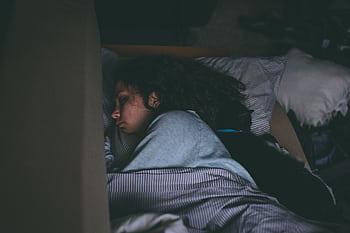 A woman sleeping peacefully with her cat, capturing a serene and cozy nighttime scene. HD wallpaper