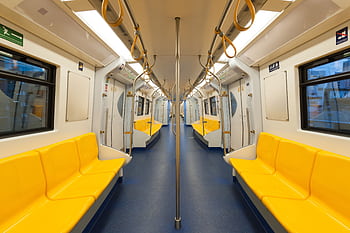 Interior of a modern subway car with bright yellow seats and clean design, emphasizing public transportation. HD wallpaper