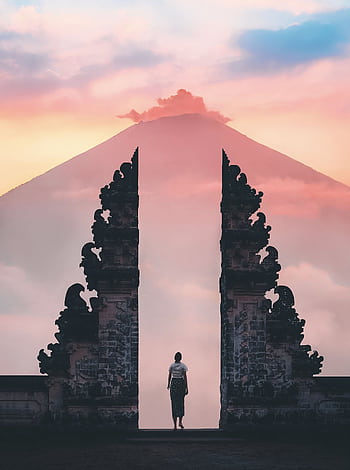 Serene sunrise view of a person standing at Lempuyang Temple's gateway, Bali, Indonesia. HD phone wallpaper