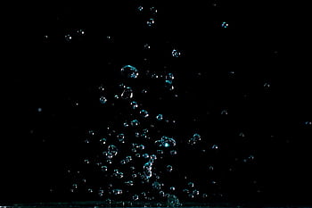 Stunning macro shot of water droplets captured against a dark background, showcasing fluid motion and natural beauty. HD wallpaper