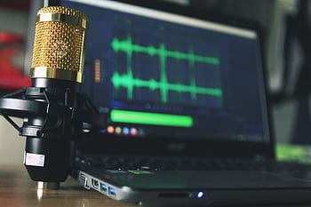 Close-up of a golden micro and laptop used for audio editing. HD wallpaper