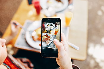 Overhead view of a person graphing a colorful brunch spread with a smart. HD wallpaper