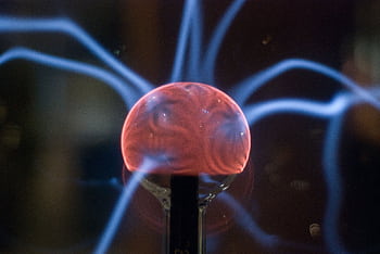 Close-up view of a plasma ball exhibiting mesmerizing electric arcs in a dark setting. HD wallpaper
