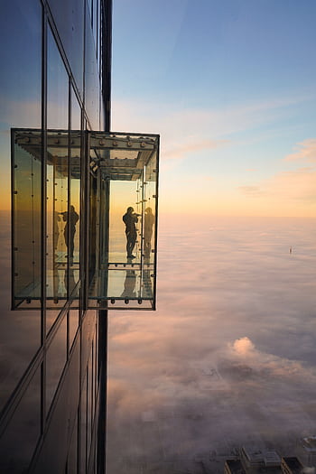 Silhouette of a person on Chicago Skydeck overlooking a foggy skyline at sunset. HD phone wallpaper