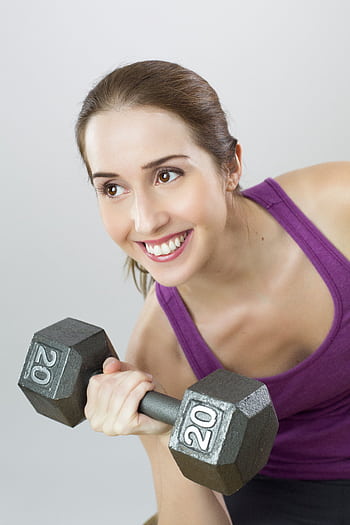 Young woman exercises with 20 lb dumbbell, showing strength and positivity. HD phone wallpaper