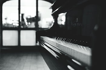Stylish black and white close-up of a piano inside a room with soft lighting. HD wallpaper