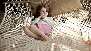 Beautiful Cute Little Girl Is Lying Down On Hanging White Swing Wearing White Pink Dress Cute HD wallpaper