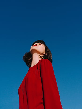 A young woman in a red blouse enjoying a clear, sunny day with a sense of dom. HD phone wallpaper