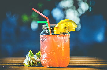 Refreshing summer citrus cocktail served in a mason jar with lemon slices and straws. HD wallpaper