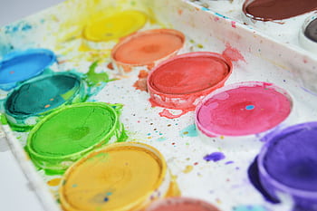 Close-up of a colorful watercolor paint palette showcasing vibrant hues for artistic creativity. HD wallpaper