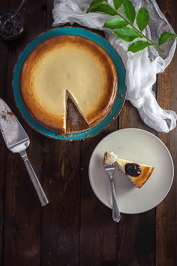 A classic cheesecake slice on a plate with a berry topping, perfect for dessert lovers. HD phone wallpaper