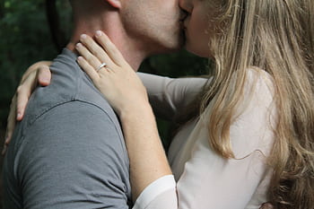 Close-up of a couple kissing outdoors, highlighting love and affection. HD wallpaper