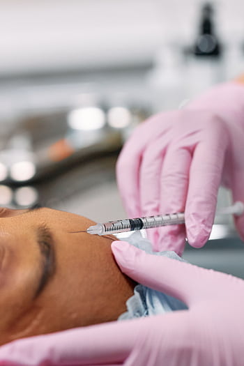 Detailed view of a cosmetic injection procedure being performed in a clinical setting. HD phone wallpaper
