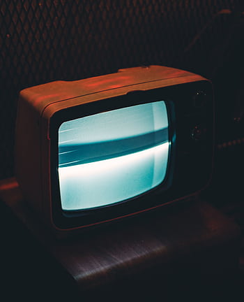 A vintage television glowing in a dark, retro ambiance. HD phone wallpaper