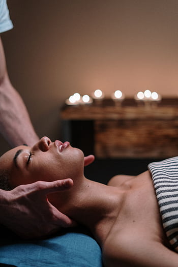A woman enjoying a relaxing face massage in a tranquil spa setting. HD phone wallpaper