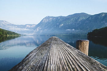 Serene view of a mountain lake from a wooden dock in Radovljica, Slovenia. HD wallpaper