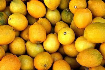 A vibrant close-up of fresh, juicy lemons perfect for healthy diets and vitamin C boost. HD wallpaper