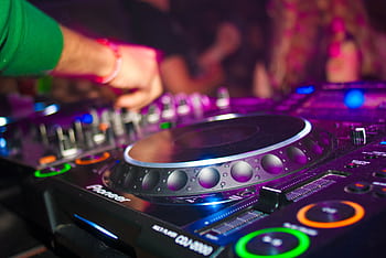Close-up of a DJ's hands on mixing console at a vibrant party in Utrecht. HD wallpaper