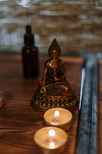 Buddha statue with candles creating a serene spa atmosphere, ideal for relaxation and mindfulness. HD phone wallpaper
