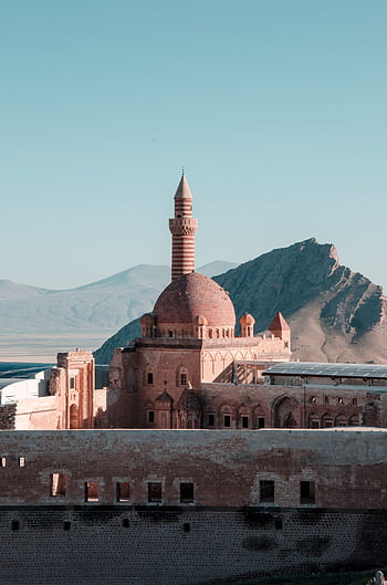 Stunning mosque architecture with minaret set against a serene mountain backdrop. HD phone wallpaper